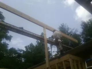 Carpenter setting a ridge beam over a new addition frame — Ice Dam Removal by Roofing Brothers in Sand Coulee