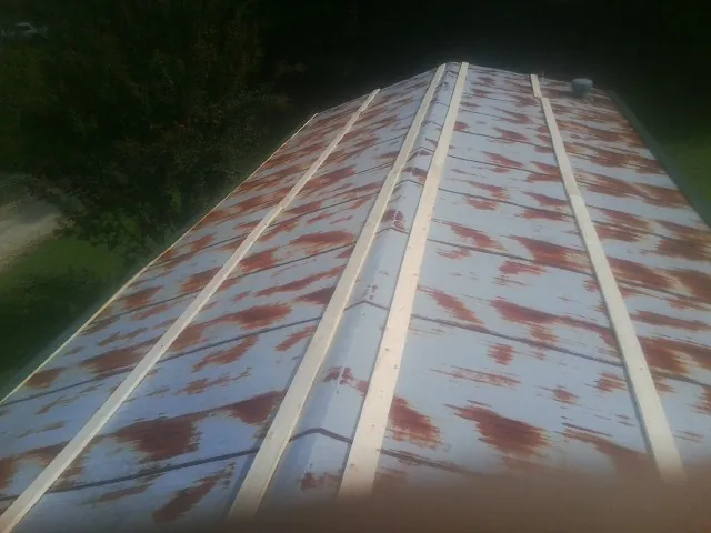 Rusted metal roof panels with new wood purlins before replacement — Storm Damage Roof Repair in Sand Coulee by Roofing Brothers