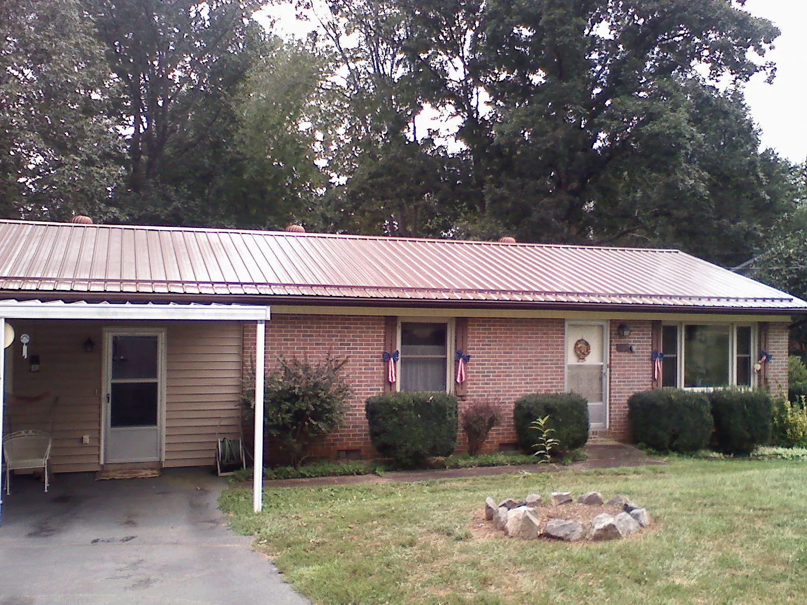 Bronze metal roof and carport on a brick ranch home — Roof Repair work by our crew in Sand Coulee
